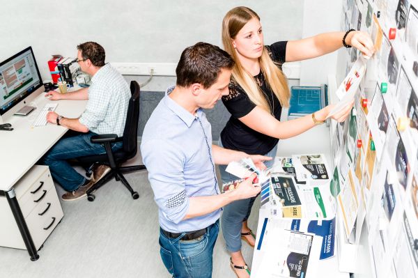 Zwei Personen arbeiten ein Marketingkonzept an einer Projektwand aus